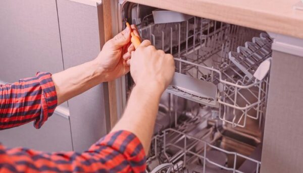 professional technician repairing dishwasher